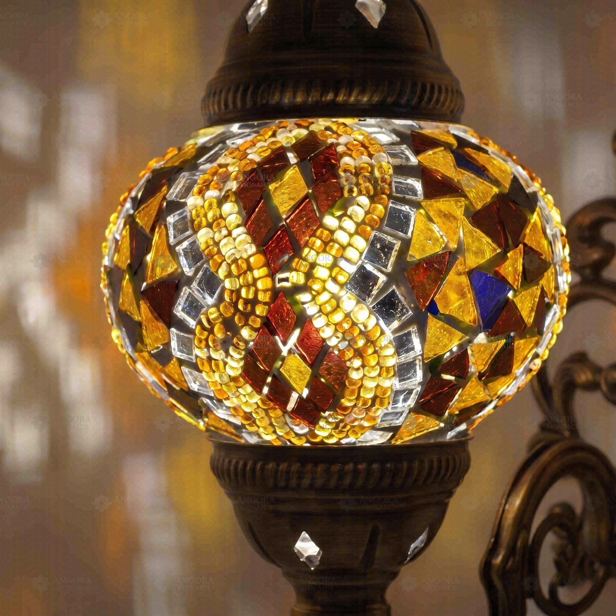 Lit close-up of mosaic glass globe — Amber wall sconce glowing (ENV APN2015)