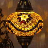 Lit close-up of mosaic glass globe — Amber wall sconce glowing (ENV APN3009)