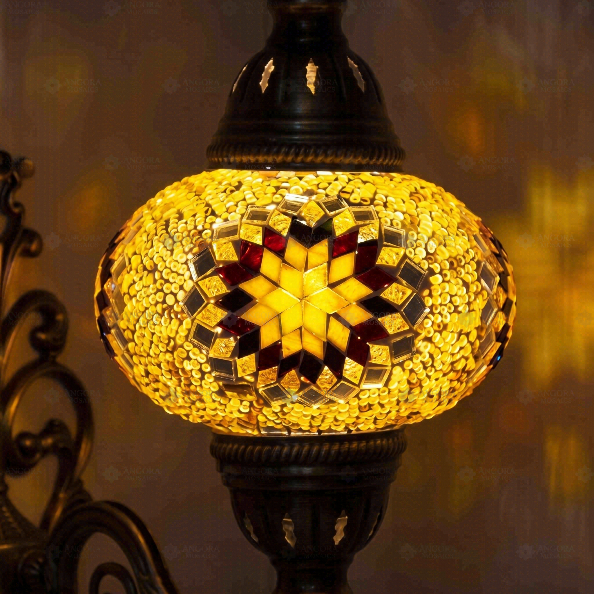 Lit close-up of mosaic glass globe — Amber wall sconce glowing (ENV APN3026)