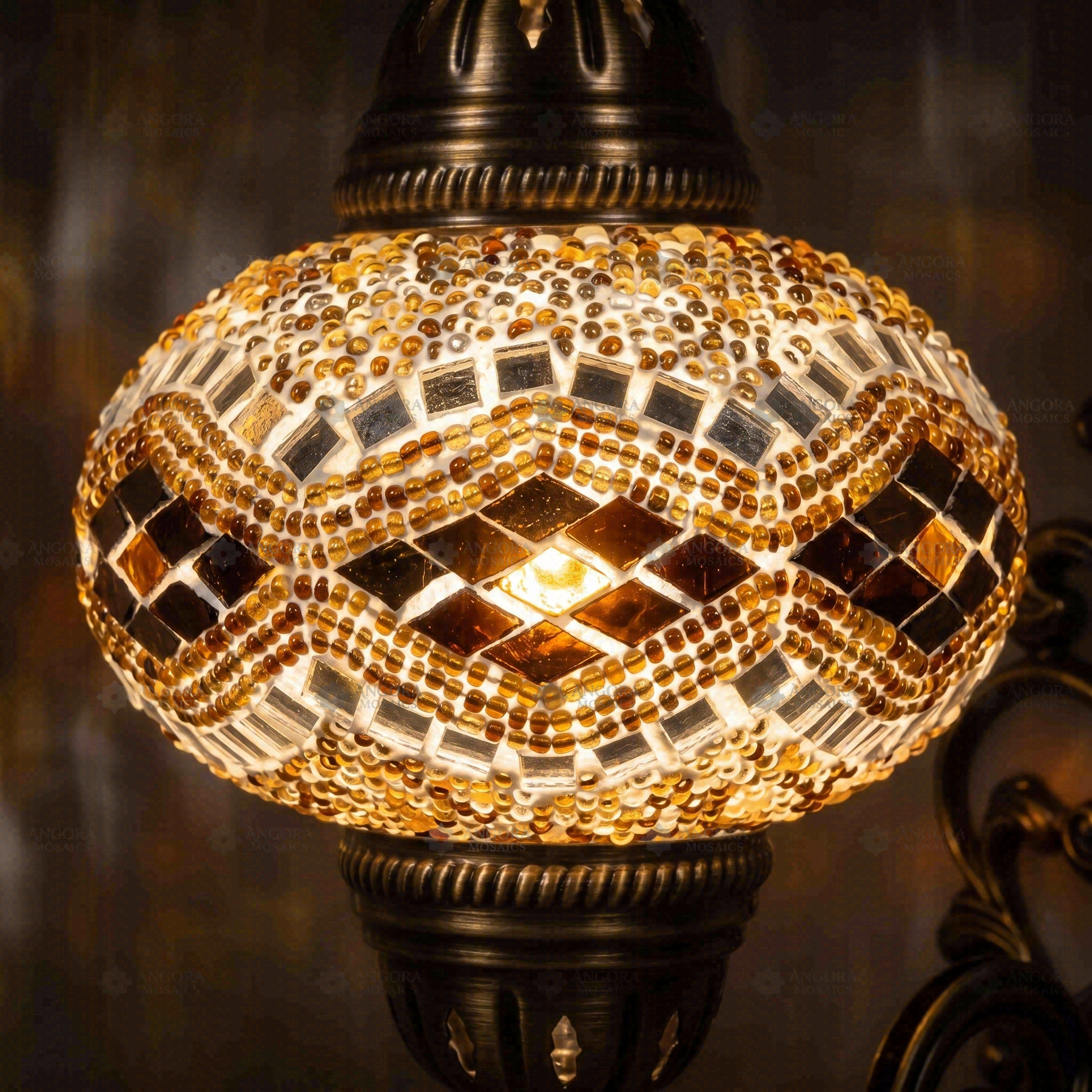 Lit close-up of mosaic glass globe — Amber wall sconce glowing (ENV APN3057)