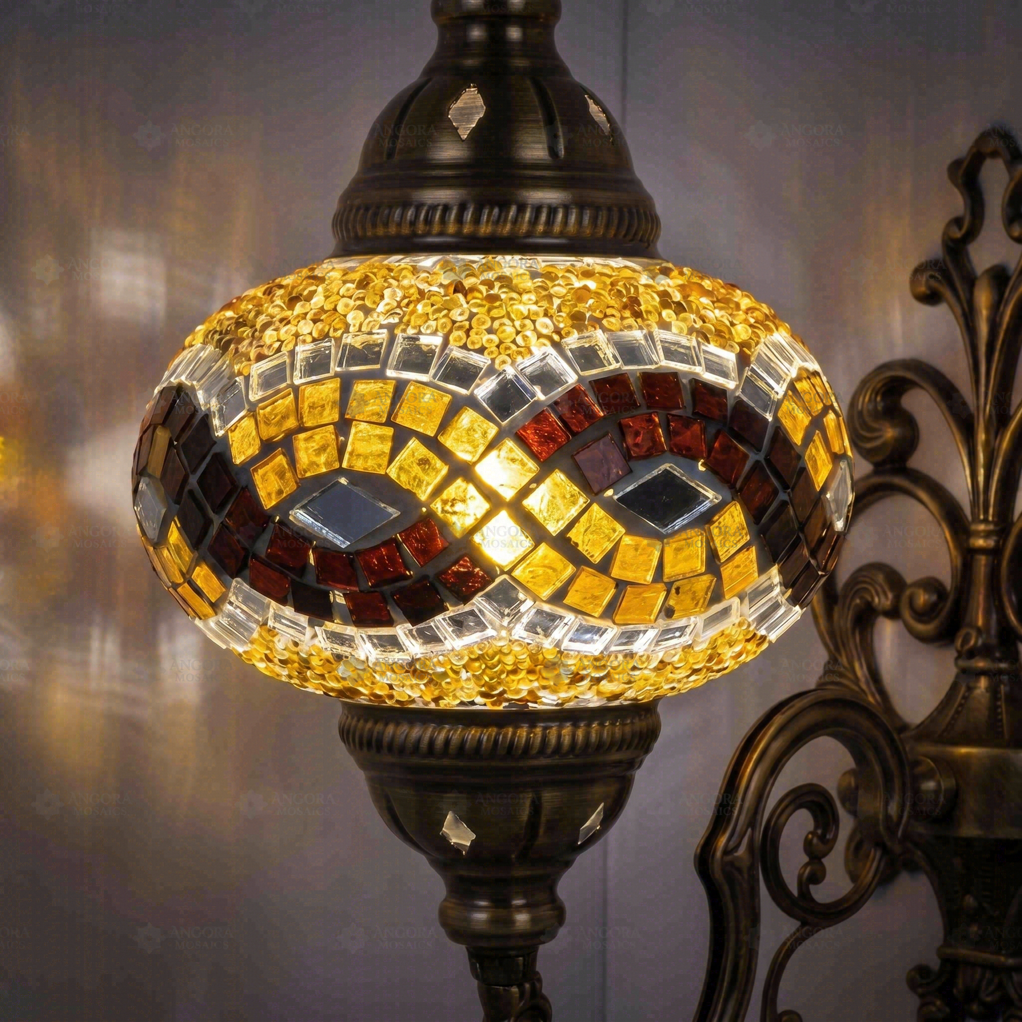 Lit close-up of mosaic glass globe — Amber wall sconce glowing (ENV APN3064)