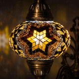 Lit close-up of mosaic glass globe — Amber wall sconce glowing (ENV APN3088)