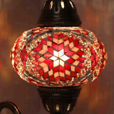 Lit close-up of mosaic glass globe — Amber wall sconce glowing (ENV APN3090)