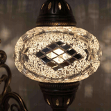 Lit close-up of mosaic glass globe — Clear wall sconce glowing (ENV APN3098)
