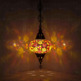 Amber Turkish mosaic pendant light illuminated, showing colorful light projection (ENV DYN3079)