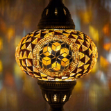 Lit close-up of mosaic glass globe — Amber pendant light glowing (ENV DYN3089)