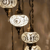 Lit close-up of mosaic glass globe — White chandelier glowing (HLZ7N3 (3022))