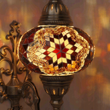Lit close-up of mosaic glass globe — Amber wall sconce glowing (ENV APN3031)