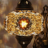 Lit close-up of mosaic glass globe — Amber wall sconce glowing (ENV APN3049)