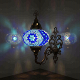 Blue Turkish mosaic wall sconce illuminated, showing colorful light projection (ENV APN3058)