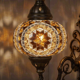 Lit close-up of mosaic glass globe — Amber wall sconce glowing (ENV APN3067)