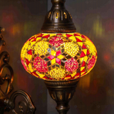 Lit close-up of mosaic glass globe — Amber wall sconce glowing (ENV APN3079)