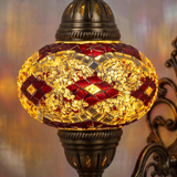 Lit close-up of mosaic glass globe — Amber wall sconce glowing (ENV APN3092)