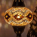 Lit close-up of mosaic glass globe — Amber wall sconce glowing (ENV APN3097)
