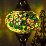 Lit close-up of mosaic glass globe — Green wall sconce glowing (ENV APN3100)
