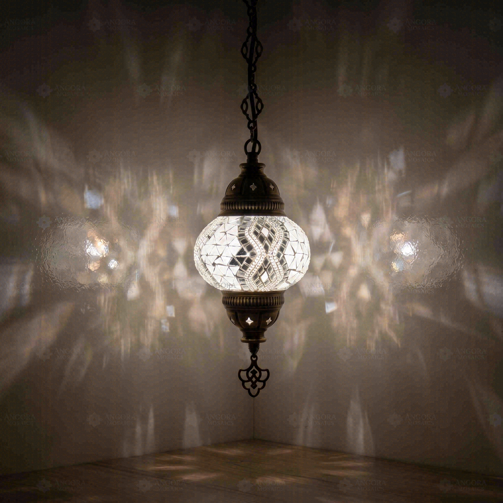 Clear Mirrored Pendant Lamp, glowing in a dark room