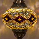 Lit close-up of mosaic glass globe — Amber table lamp glowing (ENV MUN3057)